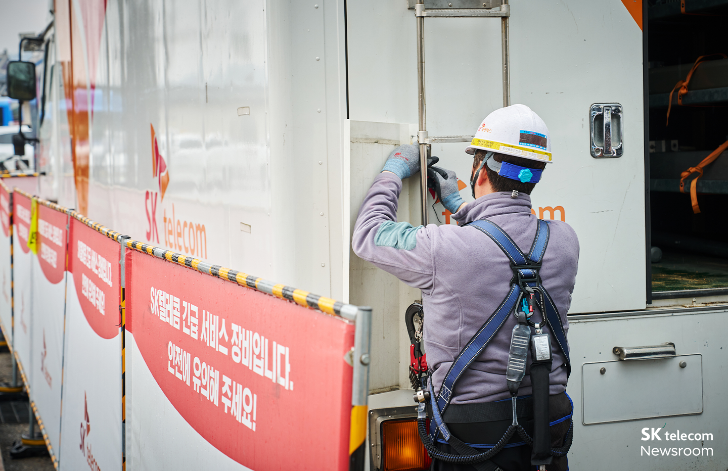 차량 상단에 오르기 전 안전고리를 체결하는 현장 작업자의 모습.