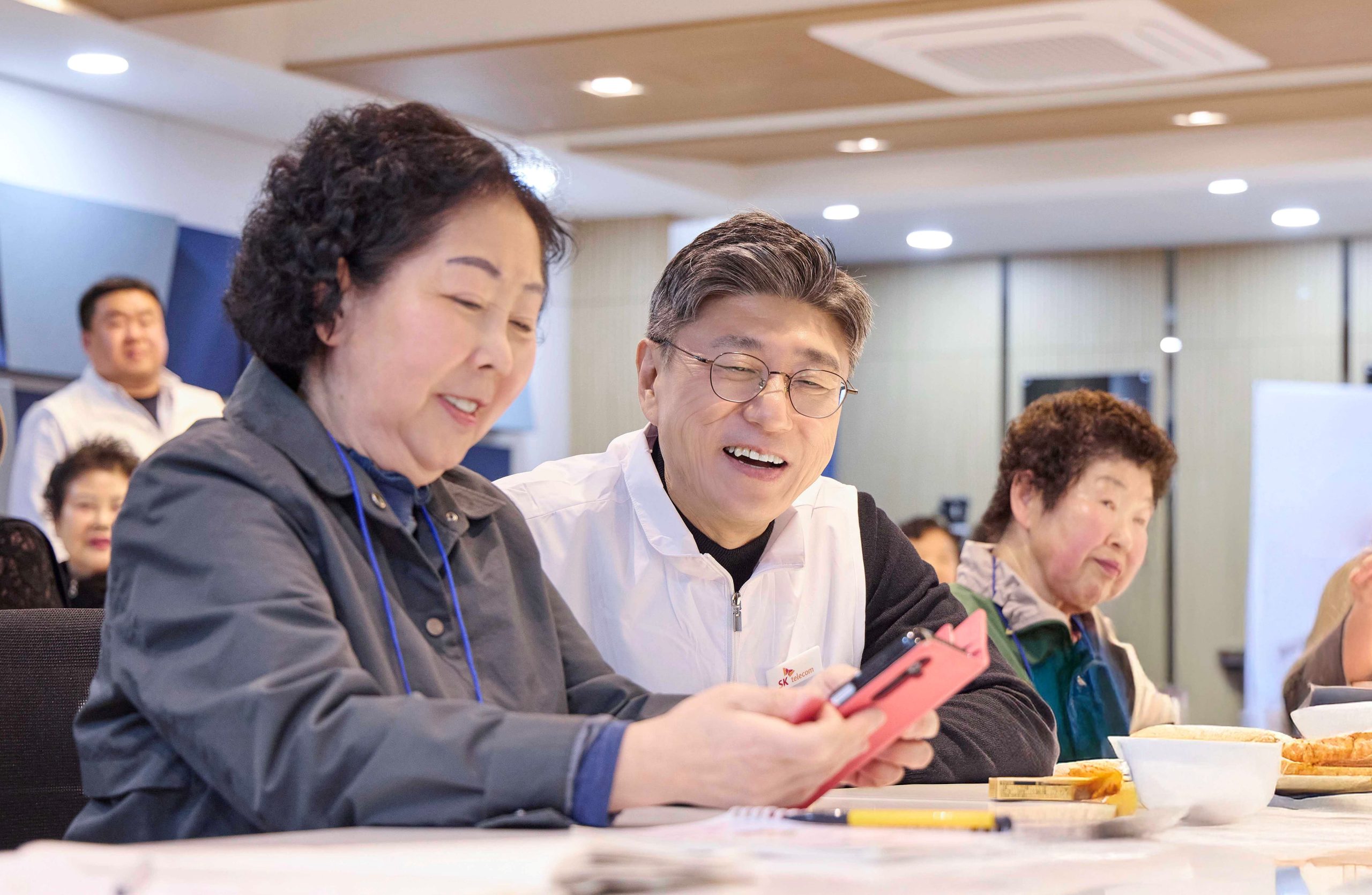 정재헌 SKT CEO가 경기도 포천시 관인노인대학에서 어르신 고객의 스마트폰을 살펴보고 대화를 나누는 모습