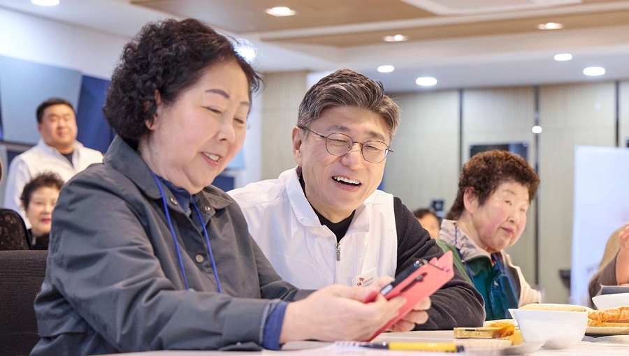 정재헌 SKT CEO가 경기도 포천시 관인노인대학에서 어르신 고객의 스마트폰을 살펴보고 대화를 나누는 모습