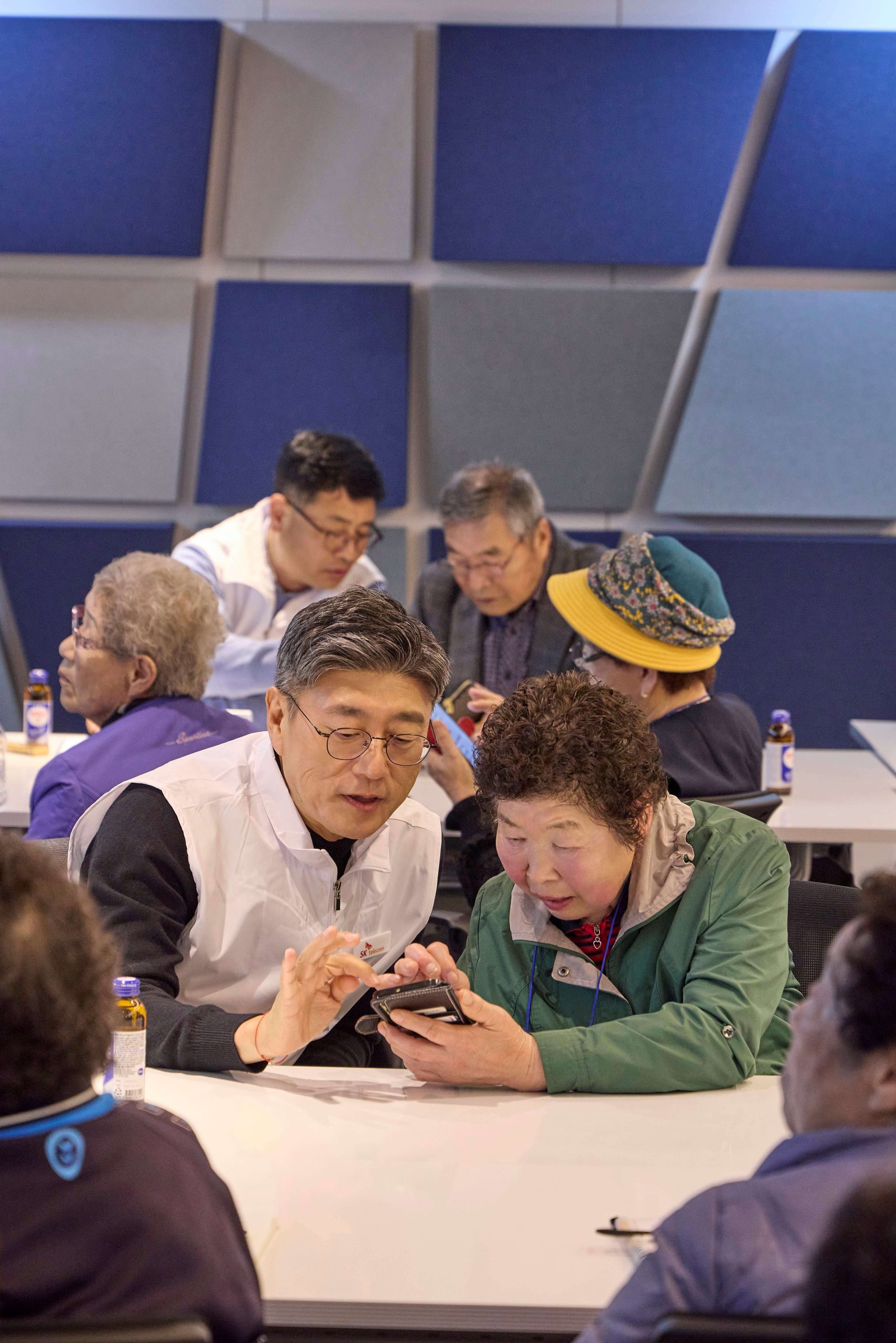 정재헌 SKT CEO가 경기도 포천시 관인노인대학에서 어르신 고객의 스마트폰을 살펴보고 대화를 나누는 모습