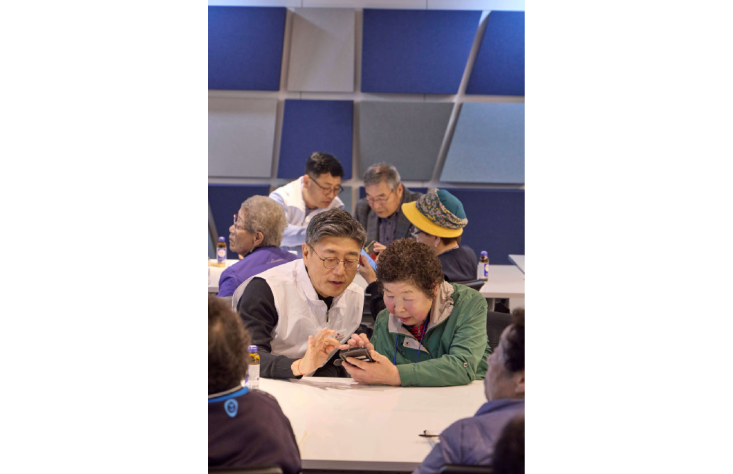 정재헌 SKT CEO가 경기도 포천시 관인노인대학에서 어르신 고객의 스마트폰을 살펴보고 대화를 나누는 모습