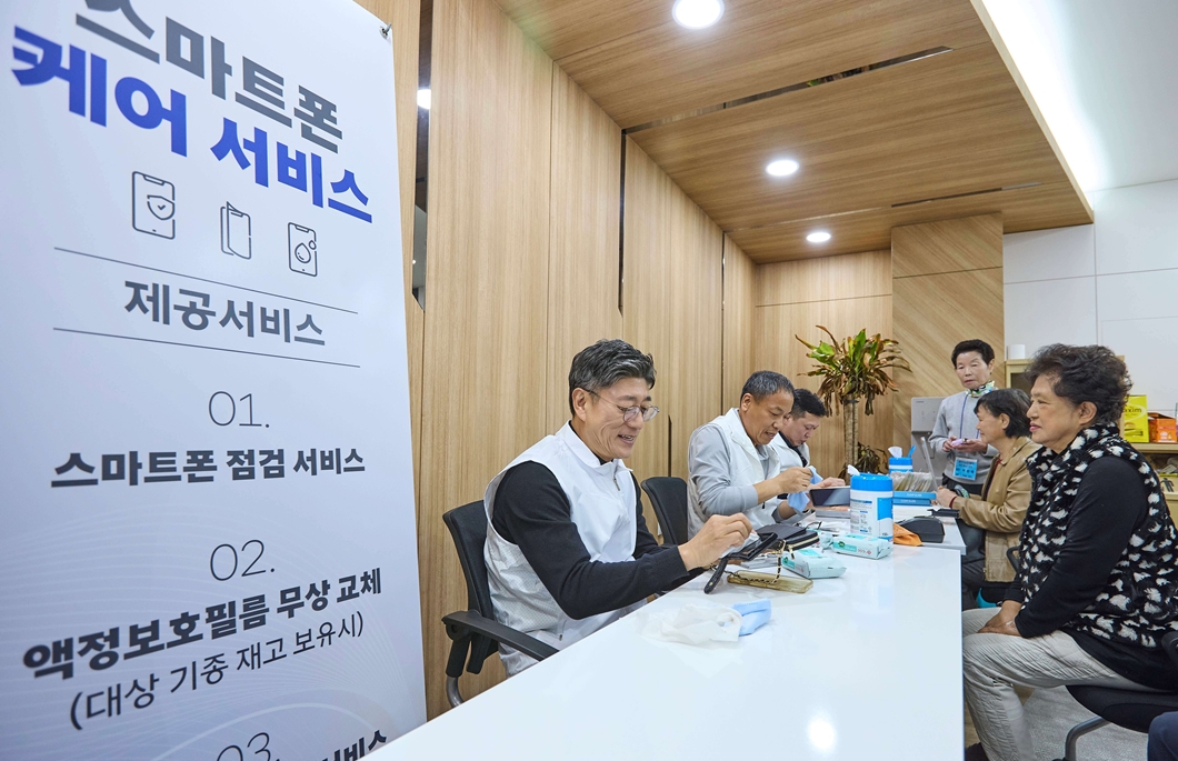 정재헌 SKT CEO가 어르신 고객의 스마트폰을 깨끗하게 닦고 있는 모습