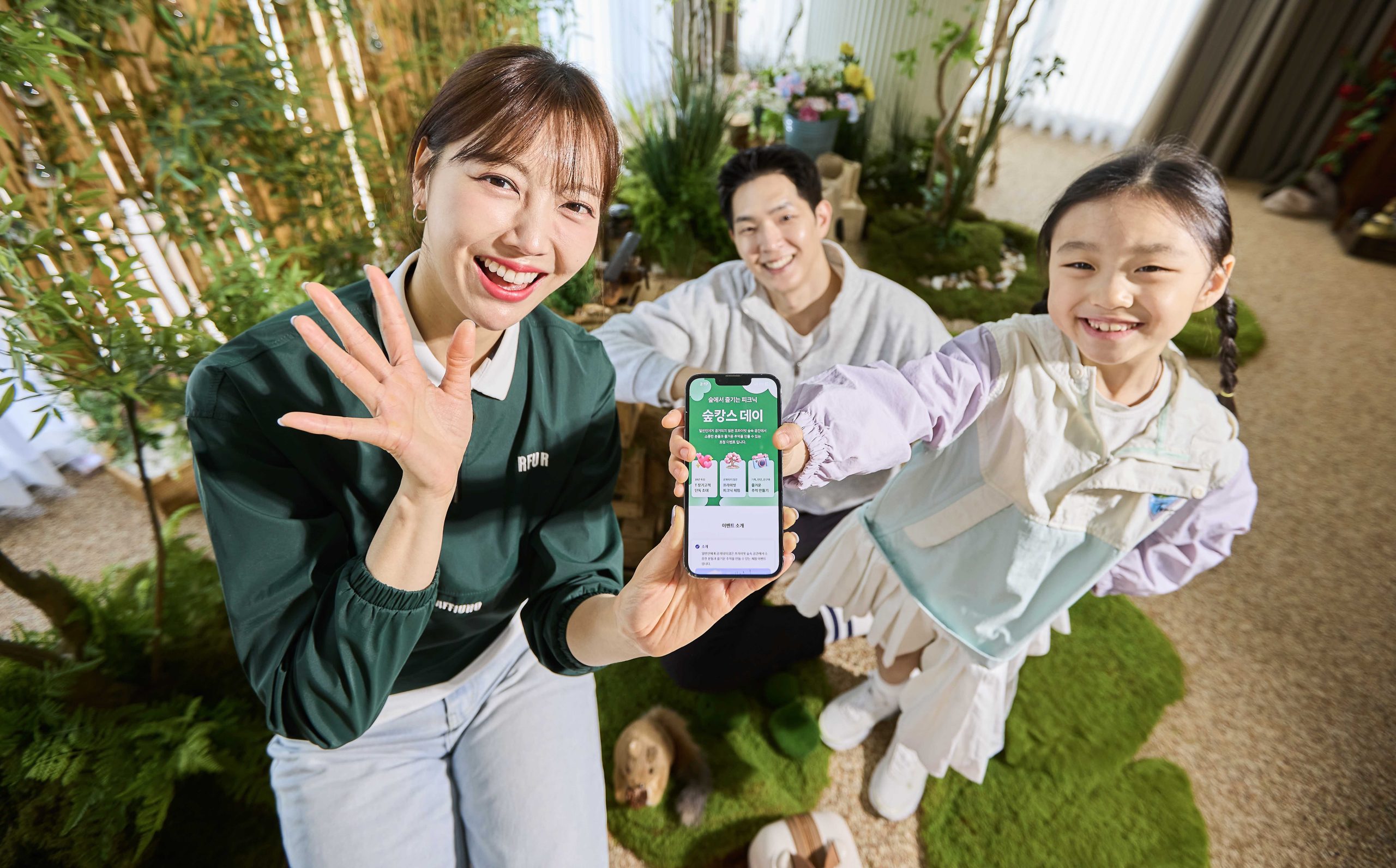 SKT 모델들이 ‘T 장기고객 숲캉스 데이’ 이벤트 페이지를 살펴보는 모습.