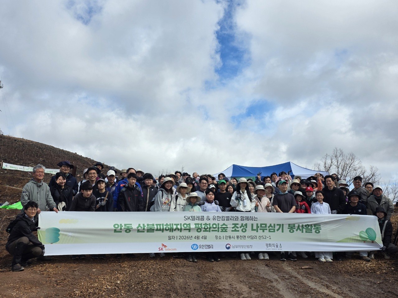 SKT와 유한킴벌리 임직원•가족 100여 명이 안동 산불 피해 지역에서 나무심기 활동을 하고 있는 모습
