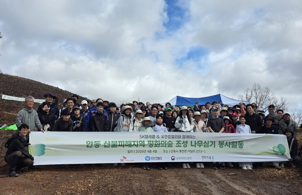 SKT와 유한킴벌리 임직원•가족 100여 명이 안동 산불 피해 지역에서 나무심기 활동을 하고 있는 모습