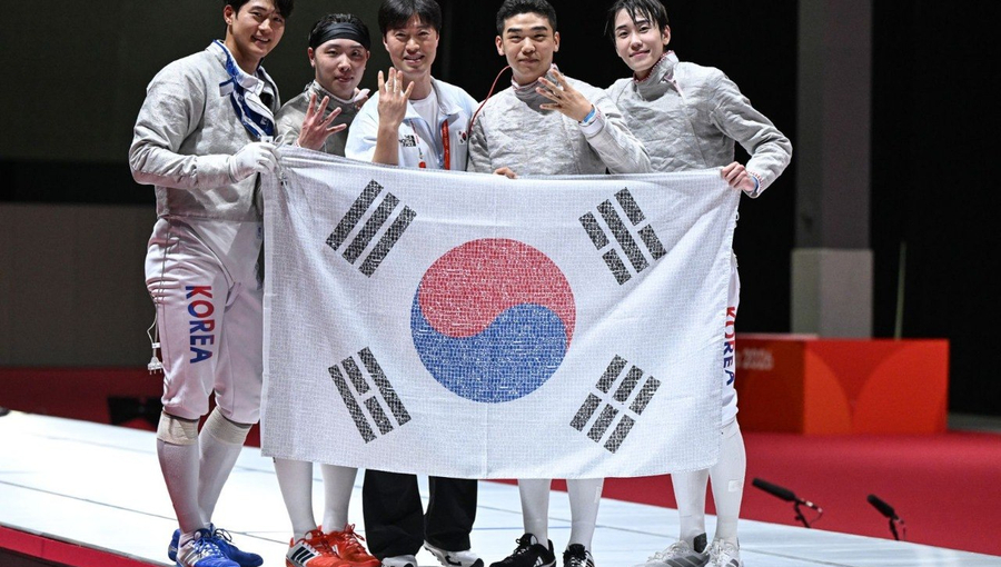 2026 아이치·나고야 아시안게임 펜싱 남자 사브르 단체전에서 4연패를 달성한 대한민국 대표팀 선수단이 국민 응원 메시지가 담긴 태극기를 들고 기념 촬영을 하고 있다.