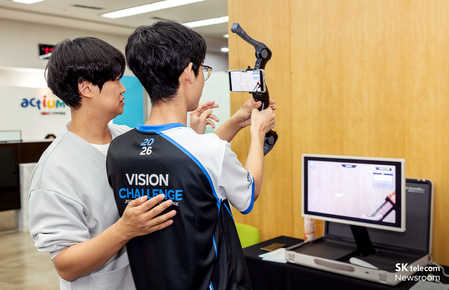 AR 장비가 설치된 활을 들고 이모티콘을 쏘아 맞추는 AR 양궁 체험 모습.